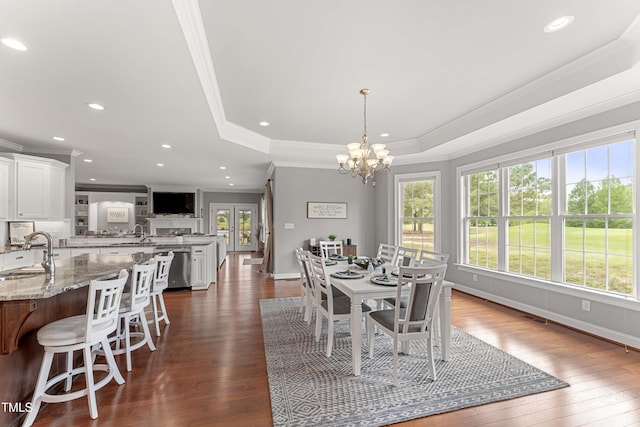 dining room featuring ornamental molding, dark wood-type flooring, a chandelier, recessed lighting, and a tray ceiling