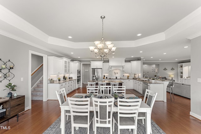 dining space with dark wood-style floors, a chandelier, crown molding, recessed lighting, and stairs