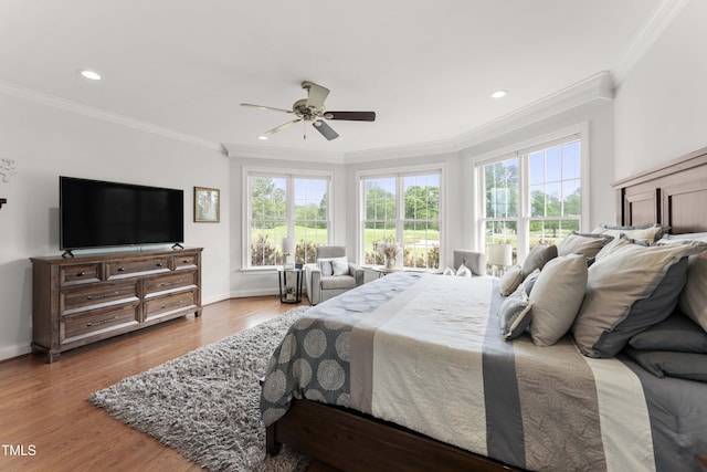 bedroom with multiple windows, ornamental molding, baseboards, wood finished floors, and recessed lighting