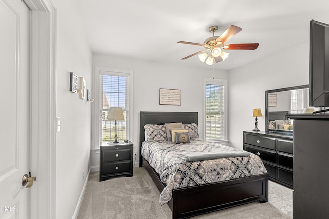 carpeted bedroom featuring baseboards and a ceiling fan