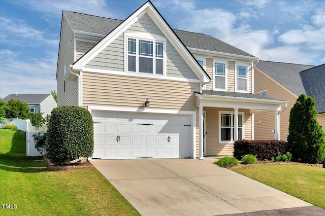 view of front facade featuring an attached garage, driveway, a front yard, covered porch, and roof with shingles