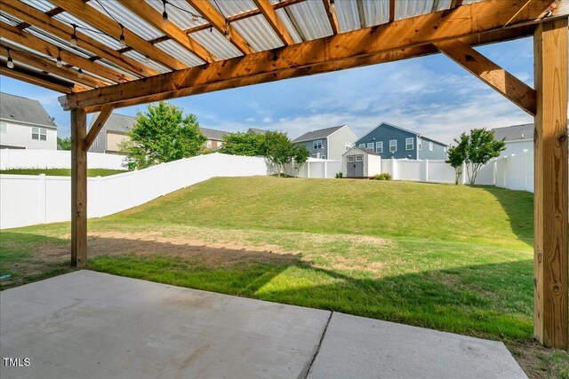 view of yard with a patio area, a residential view, a storage unit, and an outbuilding