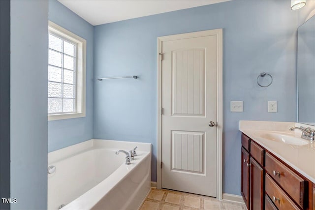full bathroom featuring healthy amount of natural light, vanity, a garden tub, and baseboards