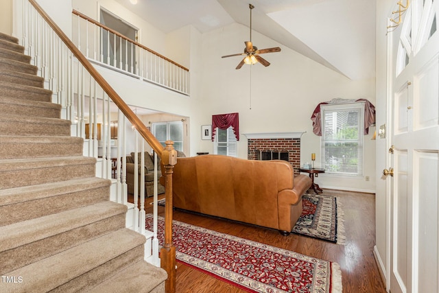 1720 Kingston Heath Way, Raleigh, NC 27604 - living area featuring stairs, a ceiling fan, wood finished floors, high vaulted ceiling, and a fireplace