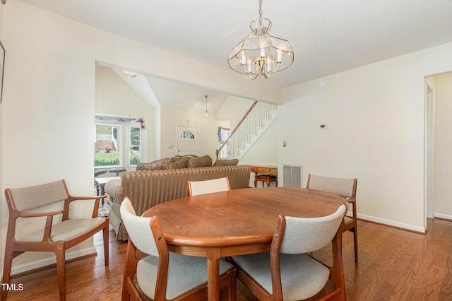 1720 Kingston Heath Way, Raleigh, NC 27604 - dining room featuring light wood-style floors, a chandelier, stairs, baseboards, and lofted ceiling