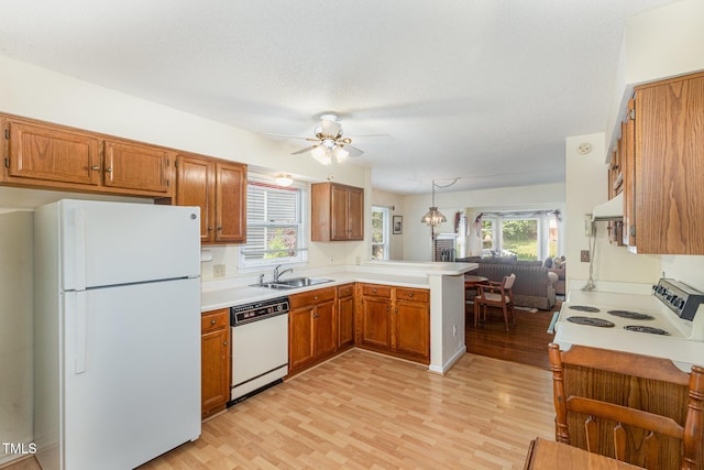 1720 Kingston Heath Way, Raleigh, NC 27604 - kitchen featuring white appliances, a sink, a peninsula, and light wood-style flooring
