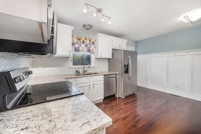 40 Crepe Myrtle Ct, Angier, NC 27501 - kitchen with a sink, stainless steel appliances, decorative backsplash, white cabinetry, and wainscoting