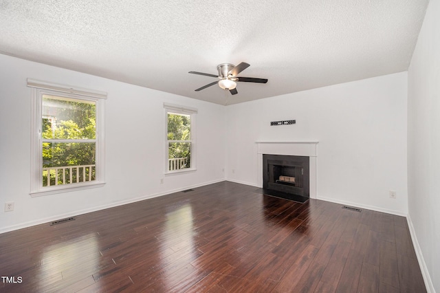 40 Crepe Myrtle Ct, Angier, NC 27501 - unfurnished living room with ceiling fan, dark wood-type flooring, a textured ceiling, a fireplace with flush hearth, and baseboards