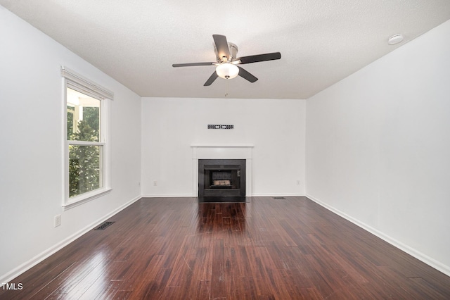40 Crepe Myrtle Ct, Angier, NC 27501 - unfurnished living room with a ceiling fan, dark wood-style floors, a fireplace with flush hearth, baseboards, and a textured ceiling