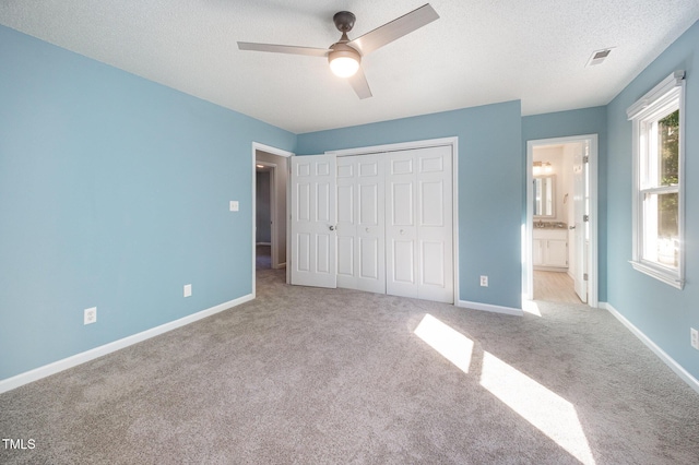 40 Crepe Myrtle Ct, Angier, NC 27501 - unfurnished bedroom with carpet flooring, a closet, baseboards, a ceiling fan, and ensuite bath