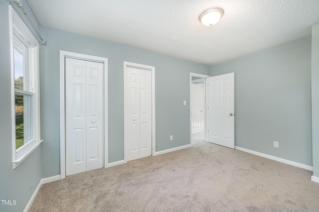 40 Crepe Myrtle Ct, Angier, NC 27501 - unfurnished bedroom with multiple closets, carpet flooring, multiple windows, baseboards, and a textured ceiling