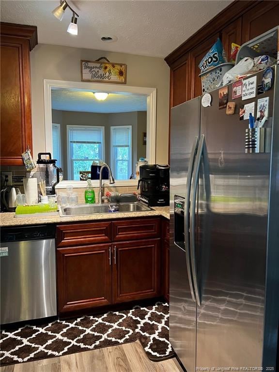 6651 Brookshire St, Fayetteville, NC 28314 - kitchen featuring stainless steel appliances, a sink, light countertops, wood finished floors, and reddish brown cabinets