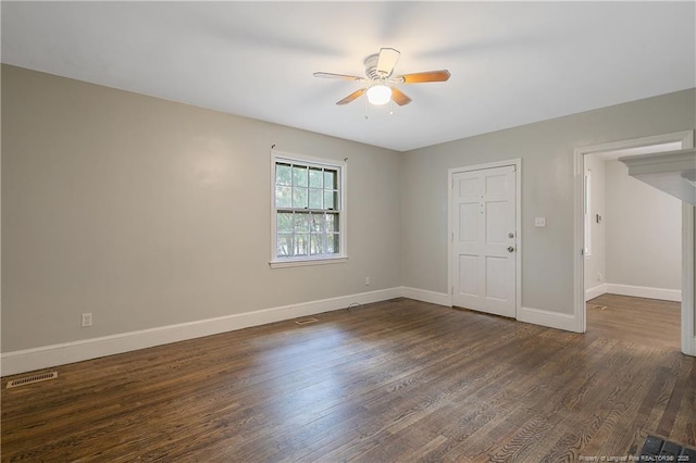 unfurnished room with a ceiling fan, dark wood-style flooring, and baseboards