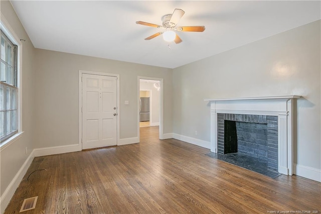 unfurnished living room featuring wood finished floors, ceiling fan, baseboards, and plenty of natural light