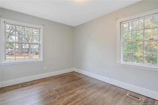 spare room with wood finished floors and baseboards