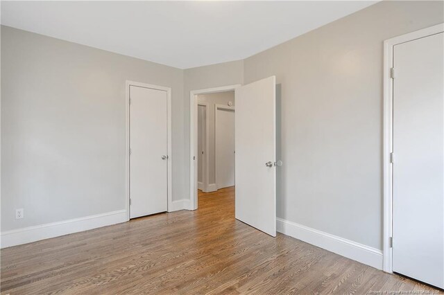 unfurnished room with wood finished floors and baseboards