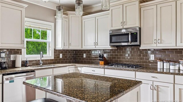 4323 Saleeby Way, Fayetteville, NC 28306 - kitchen with appliances with stainless steel finishes, a sink, backsplash, ornamental molding, and dark stone countertops