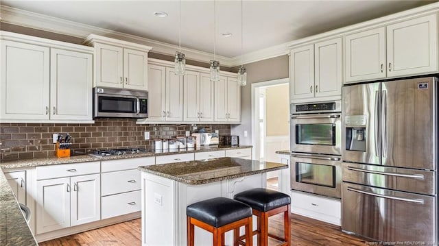 4323 Saleeby Way, Fayetteville, NC 28306 - kitchen featuring appliances with stainless steel finishes, wood finished floors, dark stone counters, tasteful backsplash, and crown molding