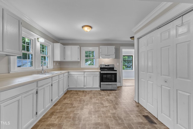 302 Hester St, Knightdale, NC 27545 - kitchen with stainless steel electric stove, under cabinet range hood, brick patterned flooring, a sink, and white cabinets