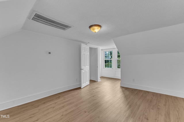 302 Hester St, Knightdale, NC 27545 - additional living space featuring wood finished floors, vaulted ceiling, baseboards, and a textured ceiling