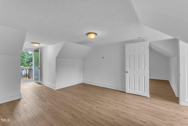 302 Hester St, Knightdale, NC 27545 - bonus room with light wood finished floors, a textured ceiling, baseboards, and vaulted ceiling