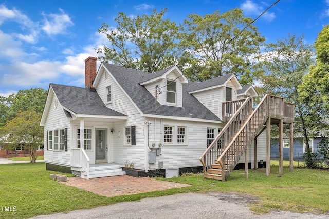 302 Hester St, Knightdale, NC 27545 - view of front facade featuring roof with shingles, a front lawn, a wooden deck, a chimney, and stairway