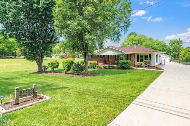 ranch-style house featuring covered porch, concrete driveway, a front yard, and brick siding
