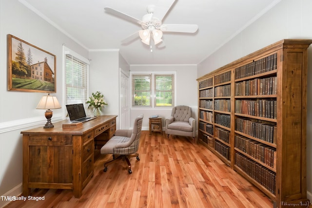 office area with light wood-type flooring, a ceiling fan, and ornamental molding