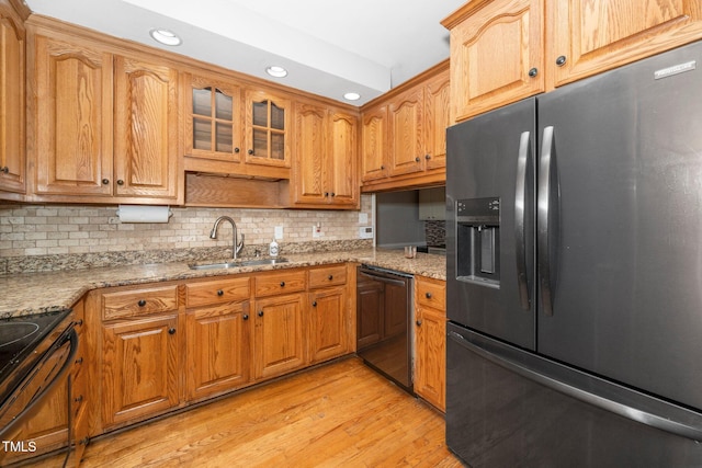 kitchen featuring black fridge with ice dispenser, dishwashing machine, a sink, range with electric stovetop, and recessed lighting