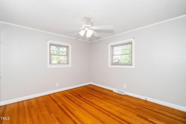 spare room featuring baseboards, light wood finished floors, ornamental molding, and a ceiling fan