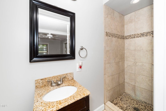 full bath with a tile shower, vanity, and a ceiling fan