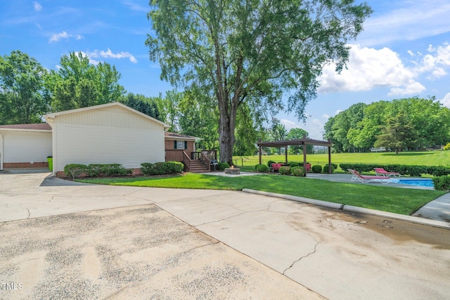 view of side of property featuring a lawn, a fire pit, and a patio area