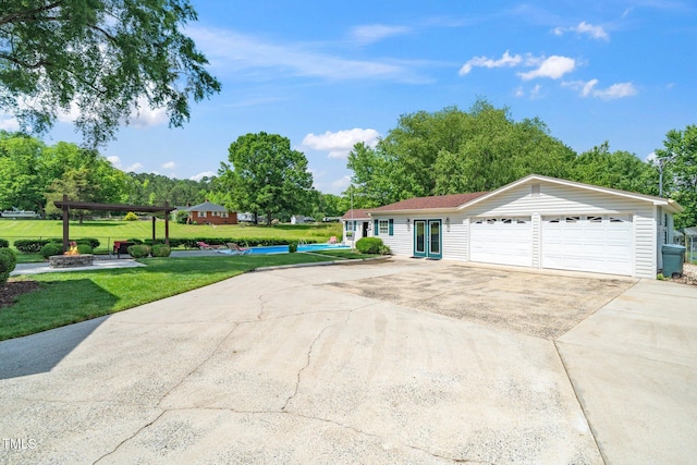 single story home featuring driveway, a front yard, and an attached garage