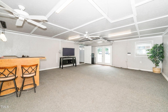 living area featuring a bar, ceiling fan, carpet, and baseboards