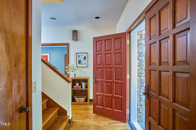 foyer featuring light wood-style flooring and stairs