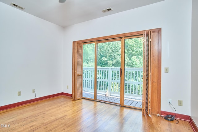 empty room with wood finished floors, baseboards, and a ceiling fan