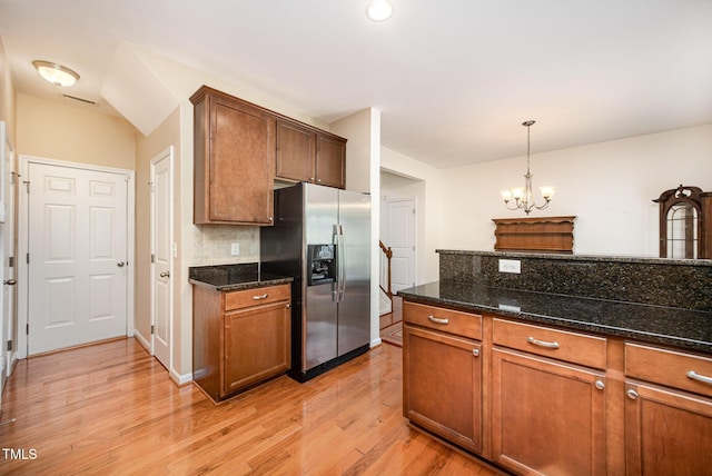 3403 Cardinal Lake Dr, Durham, NC 27704 - kitchen with stainless steel fridge, light wood-style floors, a chandelier, backsplash, and dark stone counters