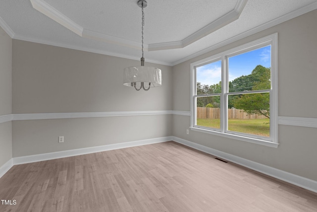 114 Lynnville Ct, Lillington, NC 27546 - empty room with a tray ceiling, a chandelier, light wood-type flooring, ornamental molding, and a textured ceiling