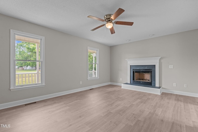 114 Lynnville Ct, Lillington, NC 27546 - unfurnished living room featuring light wood-type flooring, ceiling fan, a fireplace with raised hearth, and baseboards
