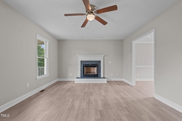 114 Lynnville Ct, Lillington, NC 27546 - unfurnished living room with a fireplace with raised hearth, light wood finished floors, a ceiling fan, and baseboards