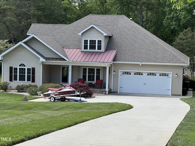 view of front of house with a porch, a standing seam roof, concrete driveway, a garage, and a front yard
