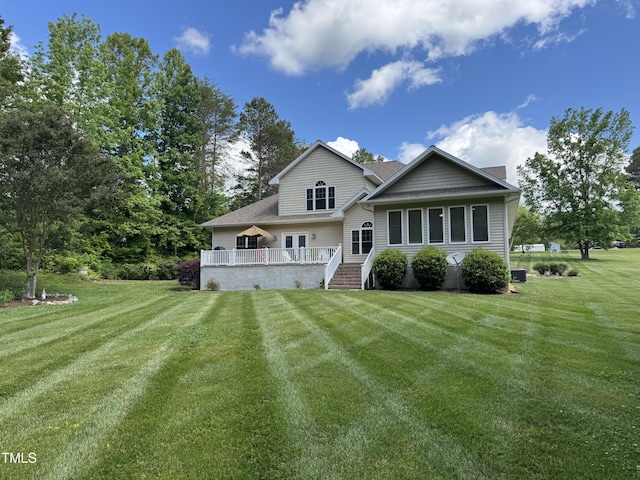 rear view of house featuring a lawn, a wooden deck, and a shingled roof