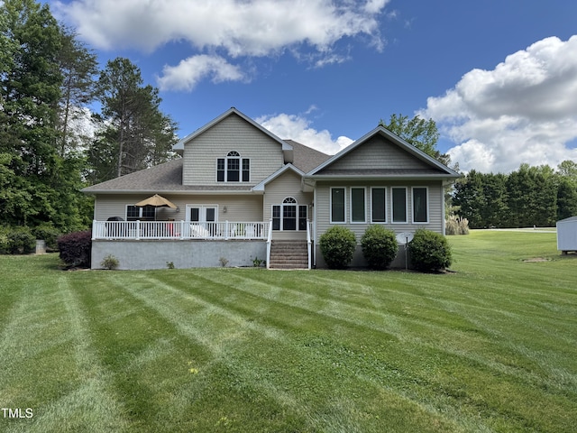rear view of house with a lawn, roof with shingles, and a wooden deck