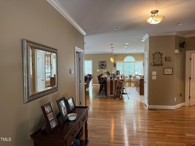 living area featuring ornamental molding, light wood-style floors, baseboards, and recessed lighting