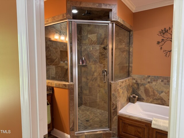 bathroom with ornamental molding, a shower stall, and a bath