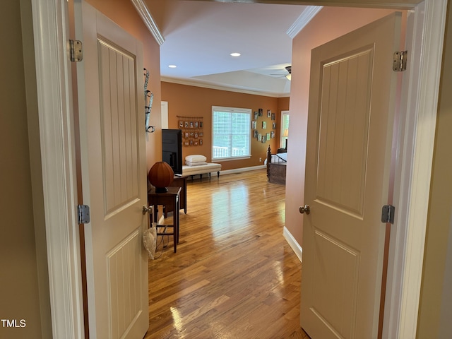 hallway featuring ornamental molding, light wood finished floors, baseboards, and recessed lighting