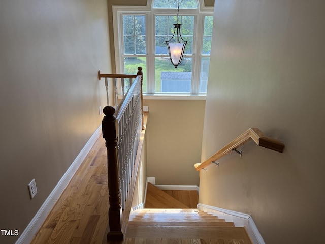 stairway featuring baseboards and wood finished floors