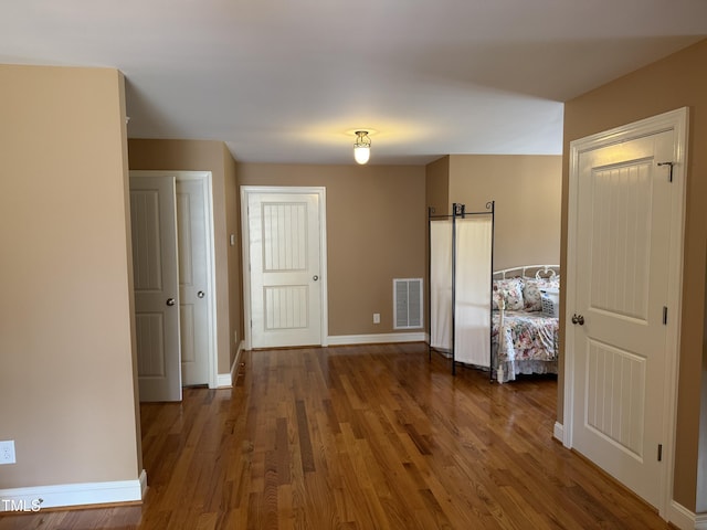 unfurnished bedroom with baseboards and wood finished floors