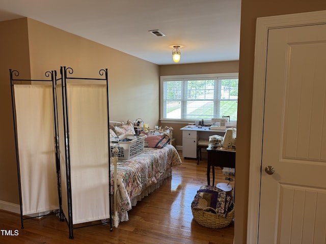 bedroom with wood finished floors and baseboards