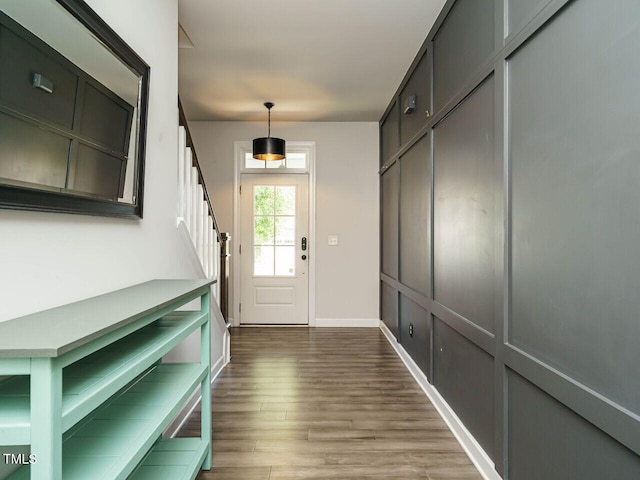 entryway featuring wood finished floors, stairway, and baseboards